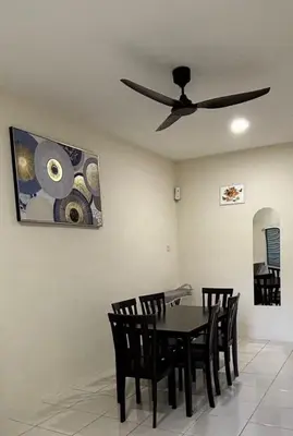 a dining room with a ceiling fan and a table and chairs at EcoPutra Stay in Ipoh