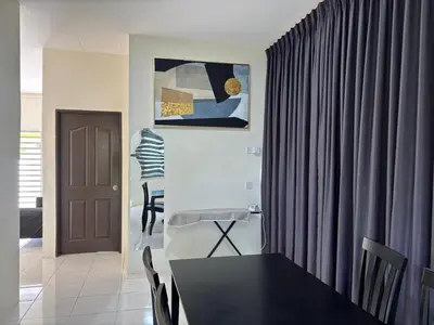 a dining room with a table and a curtain at EcoPutra Stay in Ipoh
