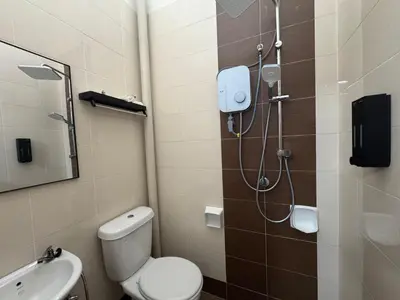a bathroom with a shower with a toilet and a sink at Sour'd Staycation Near Teluk Senangin Beach in Kampong Batu Tiga