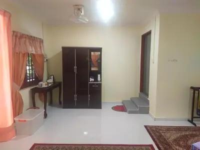 a living room with a cabinet and a table at Teratak Desa Cemerlang 3 in Kuala Kangsar