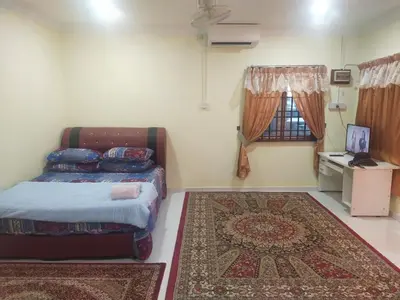 a bedroom with a bed and a rug and a window at Teratak Desa Cemerlang 3 in Kuala Kangsar