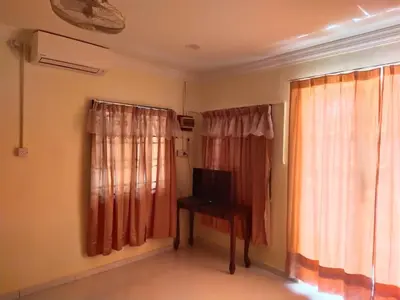 a room with a television and a table and curtains at Teratak Desa Cemerlang 3 in Kuala Kangsar