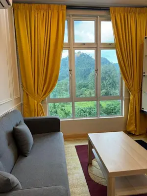 a living room with a couch and a large window at Ipoh Anderson Residence in Ipoh