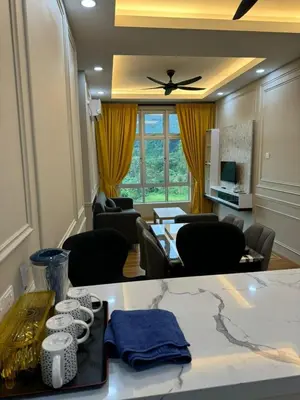 a living room with a table and chairs and a ceiling fan at Ipoh Anderson Residence in Ipoh