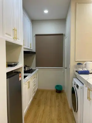 a kitchen with white cabinets and a black refrigerator at Ipoh Anderson Residence in Ipoh