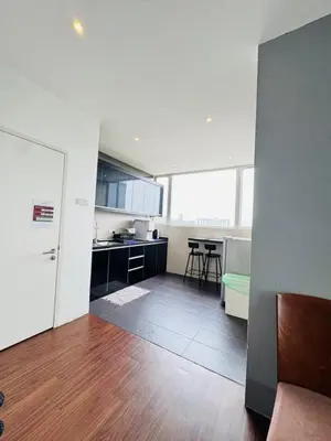 a kitchen with white walls and a wooden floor at AYAAN Foosball Penthouse at Golden Hill with Private Parking and Netflix in Brinchang