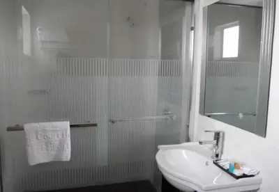 a white bathroom with a sink and a shower at Hotel Grand Court Inn in Sungai Besar