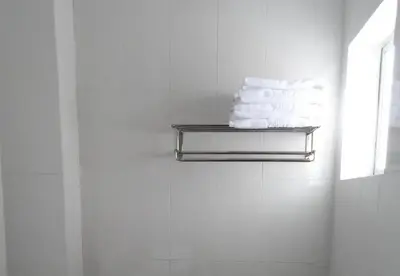 a towel rack in a bathroom with towels at Hotel Grand Court Inn in Sungai Besar
