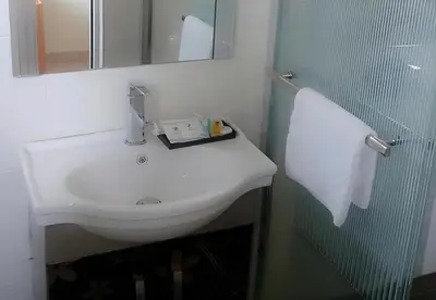 a bathroom with a white sink and a mirror at Hotel Grand Court Inn in Sungai Besar