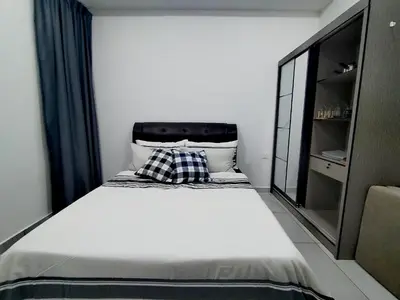 a bedroom with a large bed with a pillow on it at Sinaran Residences in Batu Kawan