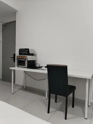 a white desk with a black chair and a microwave at Sinaran Residences in Batu Kawan
