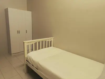 a small bedroom with a bed and a cabinet at damai homestay - feel like a home in Sitiawan