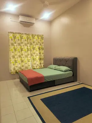 a bedroom with a bed and a curtain and rug at damai homestay - feel like a home in Sitiawan
