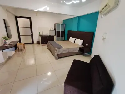 a bedroom with a bed and a couch in a room at KIMNA HOME at MARINA HEIGHT in Lumut