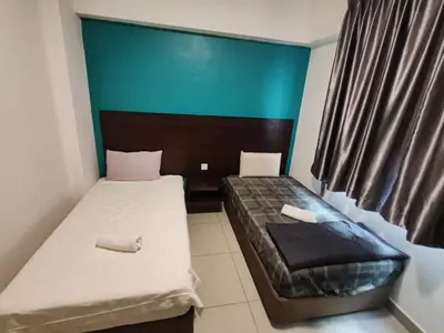 two beds in a small room with a green wall at KIMNA HOME at MARINA HEIGHT in Lumut