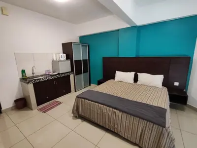 a bedroom with a bed and a blue wall at KIMNA HOME at MARINA HEIGHT in Lumut