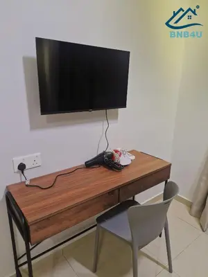 a wooden desk with a television on a wall at Minimalist Dual-Key Stay with 4BR at Farlim Penang in Ayer Itam
