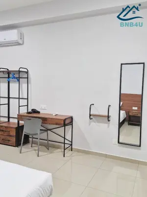 a room with a desk and a bed and a mirror at Minimalist Dual-Key Stay with 4BR at Farlim Penang in Ayer Itam