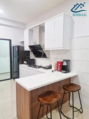 a kitchen with two stools and a counter top at Minimalist Dual-Key Stay with 4BR at Farlim Penang in Ayer Itam