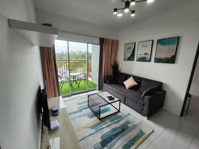 a living room with a couch and a balcony at Sweet Home G12 Emerald Avenue in Brinchang