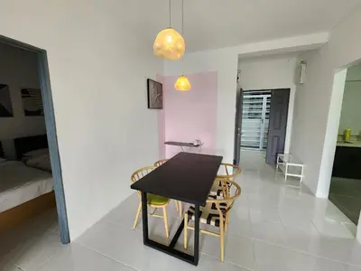 a dining room and living room with a table and chairs at Sweet Home G12 Emerald Avenue in Brinchang