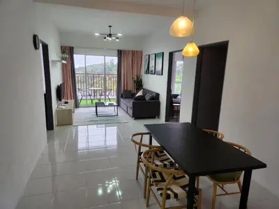 a dining room and living room with a table and chairs at Sweet Home G12 Emerald Avenue in Brinchang