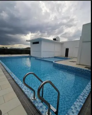 a large swimming pool with two metal hand rails in it at D'Royale NH Homestay Kompleks Mutiara Gua Musang in Gua Musang