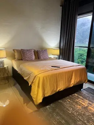 a bedroom with a large bed with a large window at D'Royale NH Homestay Kompleks Mutiara Gua Musang in Gua Musang