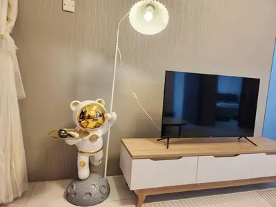 a living room with a tv and a clock on a cabinet at 6-17 Galaxy Styles Emerald Aveneu in Brinchang