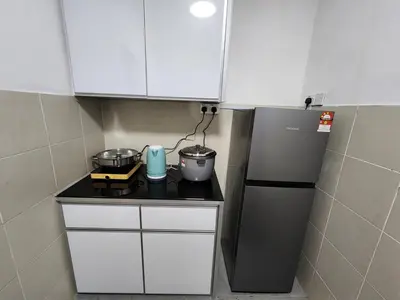 a small kitchen with white cabinets and a refrigerator at 6-17 Galaxy Styles Emerald Aveneu in Brinchang