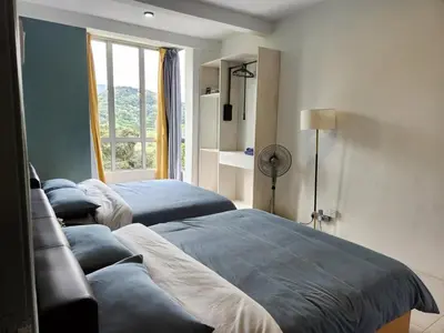 two beds in a room with a window at 8-28 The Art Gallery Emeral Avenue in Brinchang