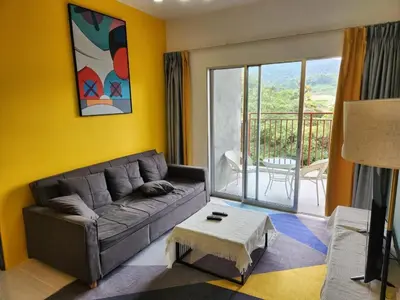 a living room with a couch and a balcony at 8-28 The Art Gallery Emeral Avenue in Brinchang