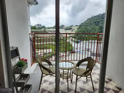 a balcony with a table and chairs and a view of a river at 821 Camping Style in Brinchang
