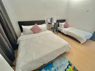 a bedroom with two beds and a table with a mirror at Cozyindah11A#7pax#netflix#NearAeonAlma#BukitMertajam in Bukit Mertajam