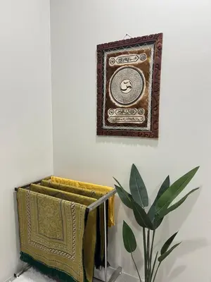 a picture frame hanging on a wall next to a plant at Nahyra Homestay, Múslīm Only, WIFI, Netflix, 4 Bilik in Sungai Petani