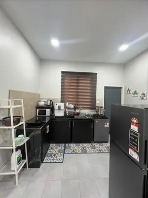 a kitchen with black counters and appliances in a room at Nahyra Homestay, Múslīm Only, WIFI, Netflix, 4 Bilik in Sungai Petani