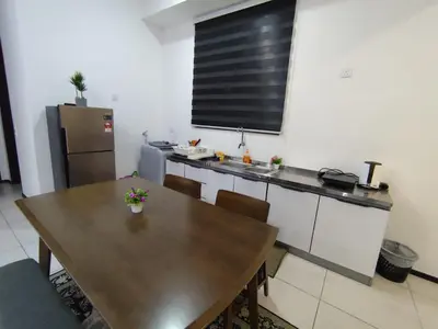 a kitchen with a wooden table and a large window at Urban Suites Penang by Dynaz Homestay in Jelutong