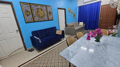 a living room with a table and a couch at Azura Homestay Seri Iskandar in Seri Iskandar