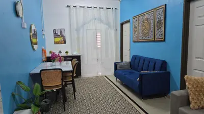 a blue living room with a table and a blue couch at Azura Homestay Seri Iskandar in Seri Iskandar