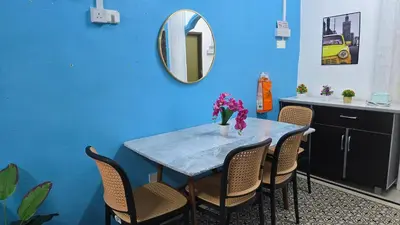 a blue room with a table with chairs and a mirror at Azura Homestay Seri Iskandar in Seri Iskandar