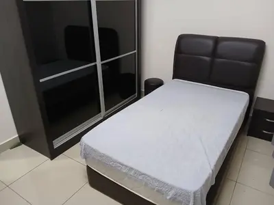 a small bed in a room with a cabinet at Adeline's Homestay Balik Pulau in Balik Pulau