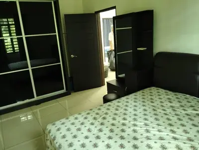 a bedroom with a bed and a dresser and a mirror at Adeline's Homestay Balik Pulau in Balik Pulau