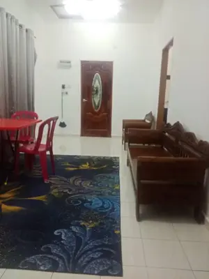 a room with a couch and a table and chairs at Homestay Saadiah in Sungai Besar