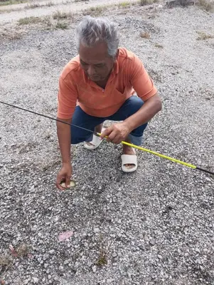 a man is holding a rope and tying his shoes at Homestay Saadiah in Sungai Besar