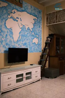 a room with a tv and a world map on a wall at City-Center Heritage Getaway for 12 Pax in George Town