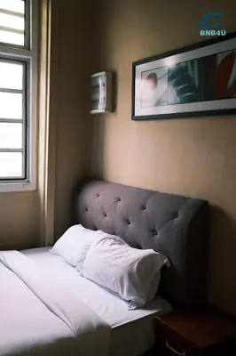 a bed in a bedroom with a picture on the wall at City-Center Heritage Getaway for 12 Pax in George Town
