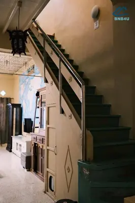 a staircase in a building with a green stair railing at City-Center Heritage Getaway for 12 Pax in George Town