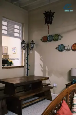 a dining room with a wooden table and a window at City-Center Heritage Getaway for 12 Pax in George Town