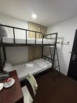 a small room with two bunk beds and a desk at Swing & Pillows - Grand Inn George Town Penang in George Town