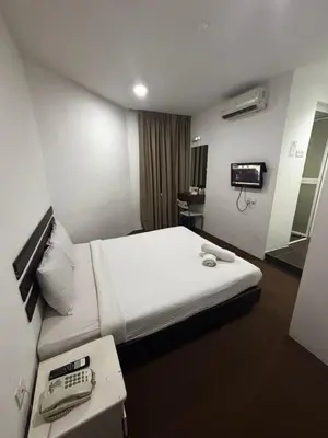 a hotel room with a bed with a phone on it at Swing & Pillows - Grand Inn George Town Penang in George Town